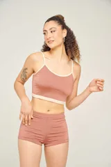 Top tankini color ladrillo con breteles finos ajustables y contorno en color crema.