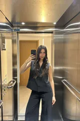 Pantalón negro de corte palazzo y tiro alto, con chaleco haciendo juego.