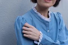 Camisa celeste de denim delgado con cuello mao y broderie en cuello y puños, de manga larga abullonada.