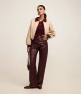 Campera bomber color beige con cuello y puños en color borgoña. Cierre frontal con cremallera y bolsillos laterales.