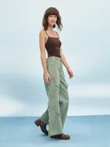 Pantalón jean de tiro alto color verde oliva, corte acampanado y detalles rotos con flecos.
