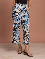 Pantalón capri estampado con flores en tonos celeste, blanco y negro. Tiene pretina elastizada en la parte trasera y bolsillos delanteros.