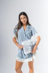 Camisa celeste con estampado a rayas verticales, de corte recto, con cuello camisero, cierre frontal con botones, mangas cortas con detalle de puntilla y ruedo con puntilla.