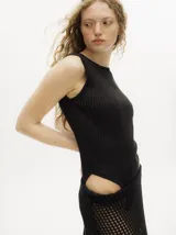 Body acanalado color rojo, de corte cavado con cuello a la base y espalda baja y abierta. Cierre inferior con botones a presión.