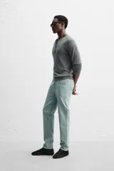 Pantalón de jean azul oscuro, corte slim fit, tiro medio, cinco bolsillos, tejido elástico y efecto lavado.