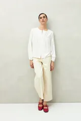 Camisa celeste de corte holgado con botones frontales, canesú con tablas y mangas 3/4 amplias con puño elastizado.