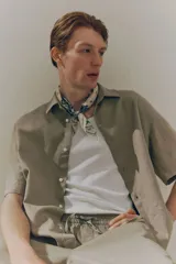 Camisa color beige de manga corta con cuello inglés y tapeta con botones. Corte holgado.