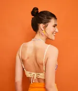 Top cropped tejido al crochet con diseño de rayas horizontales en tonos naranja, rosa, violeta y amarillo.