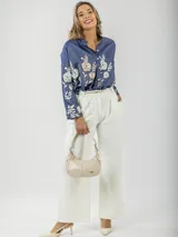 Camisa de jean azul con bordado de flores en tonos champagne y cobre, cuello mao y corte amplio.