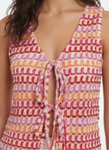 Top sin mangas de crochet con escote en V y cordón ajustable en el centro del busto. Presenta un tejido calado con patrón de ondas horizontales en tonos crema, rosa, naranja y rojo.