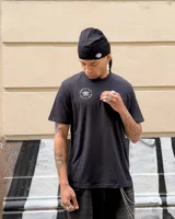 Remera color crema de corte clásico con cuello redondo y estampado en la espalda de una huella digital con forma de pelota de fútbol y el logo de Umbro.