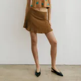 Minifalda marrón con caderín y volado. Cierre invisible en la parte trasera.