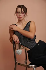 Body negro con escote redondo y apliques de strass plateados en el frente. Presenta corte cut-out en los laterales y cierre con lazos.