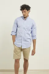 Camisa celeste de manga larga con cuello abotonado, corte clásico y bolsillo en el pecho.