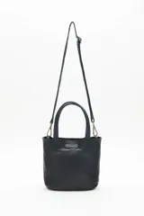 Cartera tote negra de cuero vacuno con tachas metálicas plateadas y doradas. Tiene doble asa corta y correa larga desmontable. Forro interior de algodón.