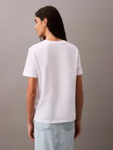 Remera blanca de algodón con cuello redondo y logo de Calvin Klein en el pecho.