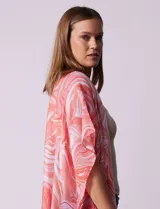 Kimono tejido con estampado abstracto en tonos grises y blancos, con mangas cortas y terminación de ruedo con borlas negras.
