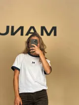 Remera blanca de algodón con cuello redondo y mangas cortas con puños en lurex azul marino.