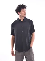 Camisa negra de manga corta con cuello clásico y cierre frontal con botones.