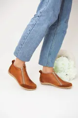 Botines de cuero con doble cierre, diseño informal y suela de goma texturizada.