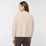 Sweater beige de punto suave, con cuello redondo y mangas largas. Diseño holgado y tejido texturizado.