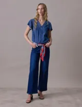 Blusa celeste de tencel con escote en V y botones. Tiene mangas cortas amplias con volados.