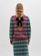 Cardigan de algodón con estampado de rombos en tonos marrón, beige y azul. Tiene cuello camisero, cierre frontal con botones azules y calce suelto.