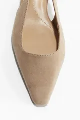 Zapato destalonado color beige de gamuza, con punta fina, tira trasera con elástico y taco kitten.