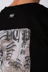 Remera color crudo de corte oversize con estampado pequeño en el centro del pecho.