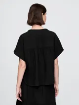 Camisa de muselina color blanco, con cuello mao y mangas cortas.