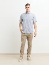 Camisa de manga corta a rayas verticales celestes y blancas, con cuello abotonado y corte clásico.