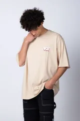 Remera blanca de corte oversize con mangas cortas y cuello redondo. Estampado pequeño en el frente con letras verdes.