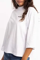 Remera blanca de corte cuadrado con cuello subido y mangas 3/4 amplias.