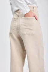 Pantalón jean de corte ancho color beige, con cintura alta y terminación desflecada.