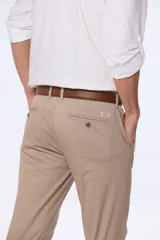 Pantalón de vestir azul marino, de corte recto, con bolsillos laterales y traseros. Se ajusta a la cintura con cinturón de cuero marrón.