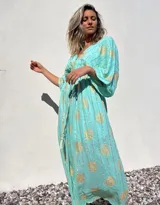 Vestido túnica largo color verde agua con estampado dorado, escote en V y mangas anchas.