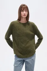 Sweater de algodón color verde oliva con textura de punto en zigzag y motas de colores. Presenta cuello redondo y mangas largas tipo ranglán, con calce holgado.
