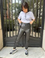 Pantalón de cuerina negro con botón y cierre, de corte chupín y ajustado.