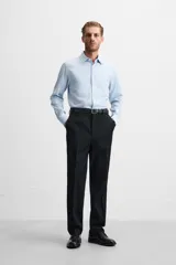 Camisa blanca de corte regular, cuello italiano, manga larga con puños abotonados y cierre frontal con botones.
