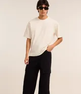 Pantalón de hombre de corte super baggy confeccionado en sarga de poliéster y algodón color negro, con bolsillos cargo laterales, cintura con trabillas y cierre de cremallera.