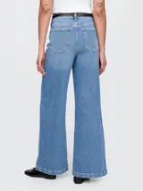 Pantalón de jean celeste de corte ancho, tiro alto y efecto degradado en el ruedo.