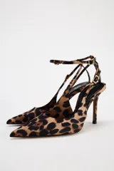 Zapato destalonado de tacón alto con estampado animal, acabado en punta y pulsera al tobillo con cierre de hebilla.