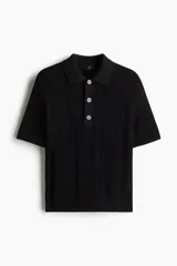 Remera polo negra de manga corta en punto trenzado con cuello clásico, tapeta de botones y bajo recto.