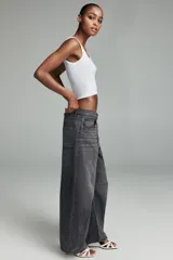 Jeans de tiro medio, estilo balloon baggy, color gris oscuro lavado. Presenta pierna muy ancha y largo completo, con aberturas sutiles en los bajos.