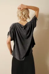 Remera gris de jersey flamé con cuello redondo y mangas cortas con cordones ajustables.