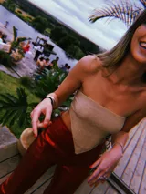 Top bandeau dorado con textura brillante y corte asimétrico en el ruedo.
