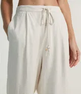 Pantalón fluido color crema, confeccionado en viscolino, con cintura elástica y lazo ajustable.