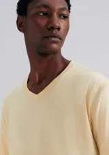 Camiseta básica unisex de color beige, con cuello en V y sin costuras laterales para mayor comodidad.