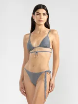 Conjunto de bikini gris con textura acanalada, compuesto por un corpiño triangular con tirantes finos y una bombacha con lazos laterales ajustables.