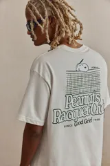 Remera blanca de corte holgado con cuello redondo y estampado de Snoopy con la leyenda "Peanuts Racquet Club" en el pecho.